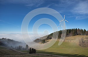 Wind power mills above fog in black forest, Germany