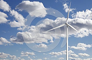 Wind-power plant against white puffy clouds