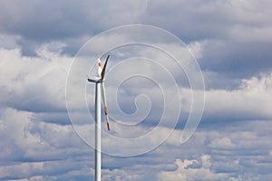 Wind power plant on the background of bright cloudy sky. wind generator close-up. green electricity, alternative energy