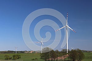 Wind power station in the daytime in the spring. Rotating blades of energy generators. Ecologically clean electricity. Modern tech