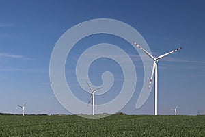 Wind power station in the daytime in the spring. Rotating blades of energy generators. Ecologically clean electricity. Modern tech