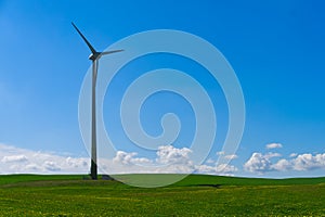 Wind power turbine against cloudy blue sky