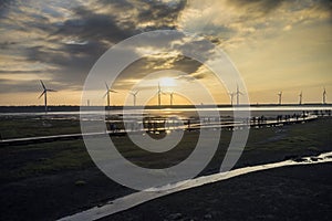 Wind power turbine at Taichung Gaomei wetlands during sunset.