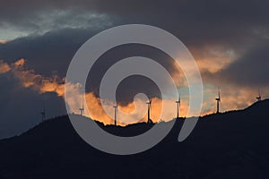 Wind power turbines on top of the mountains at dusk photo