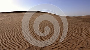 Wind and sand dunes in desert