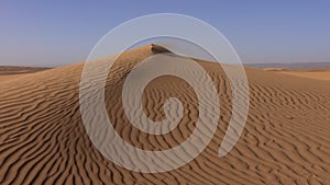 Wind and sand dunes in desert