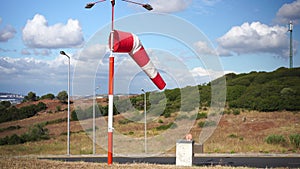 Wind sock fly. Summer hot day on private sporty airport with abandoned windsock, wind is blowing and windsock is lazy