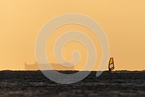 A wind surfer during dawn and heavy winds