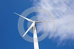 Wind turbine against blue sky, low angle view. Alternative energy source