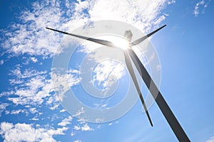 Wind turbine against blue sky, low angle view. Alternative energy source