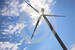 Wind turbine against blue sky, low angle view. Alternative energy source