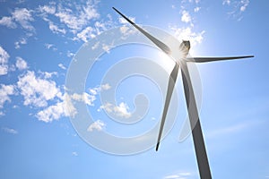 Wind turbine against blue sky, low angle view. Alternative energy source