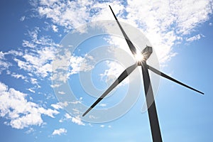 Wind turbine against blue sky, low angle view. Alternative energy source