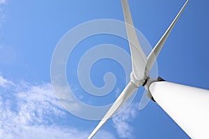 Wind turbine against blue sky, low angle view. Alternative energy source