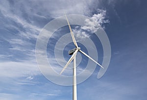 Wind turbine against a cloudy blue sky