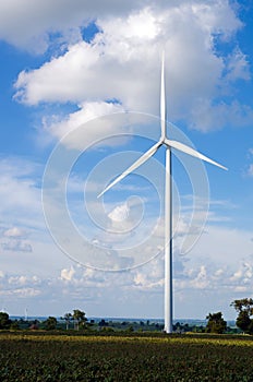 Wind turbine against cloudy blue sky