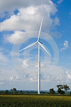 Wind turbine against cloudy blue sky