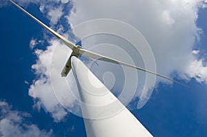 Wind turbine against cloudy blue sky