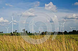 Wind turbine against cloudy blue sky