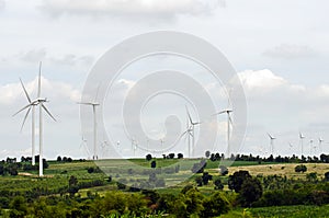 Wind turbine against cloudy blue sky background