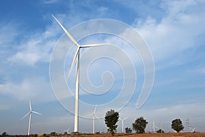 Wind turbine against cloudy blue sky background