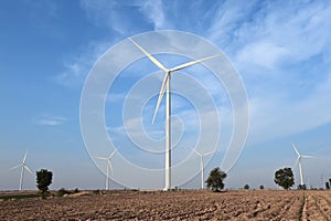 Wind turbine against cloudy blue sky background