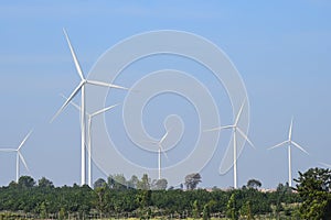 Wind turbine against cloudy blue sky background