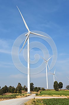 Wind turbine against cloudy blue sky background