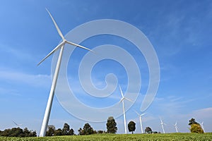 Wind turbine against cloudy blue sky background