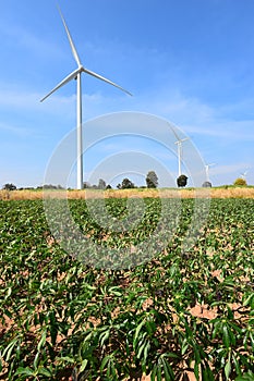 Wind turbine against cloudy blue sky background