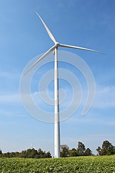 Wind turbine against cloudy blue sky background