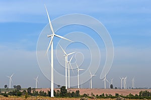 Wind turbine against cloudy blue sky background