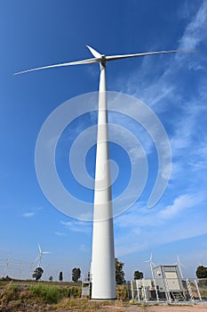 Wind turbine against cloudy blue sky background