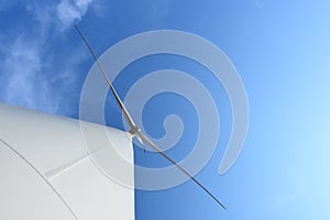 Wind turbine against cloudy blue sky background