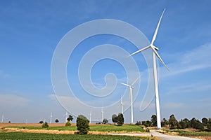 Wind turbine against cloudy blue sky background