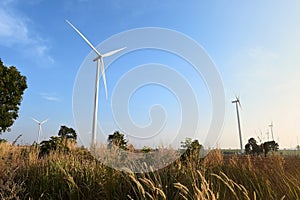 Wind turbine against cloudy blue sky background