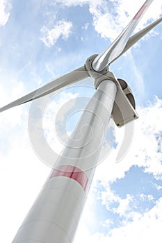 Wind turbine against cloudy sky, low angle view. Alternative energy source