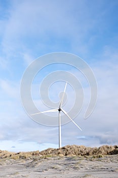 Wind Turbine Against Pastel coloured Cloudy Blue Sky at beach Landscape