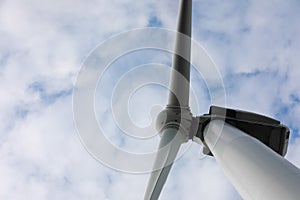 Wind turbine against sky, low angle view. Alternative energy source