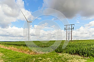 Wind turbine along with power cable in a filed in the countryside of England