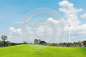 Wind Turbine for alternative energy iwith green grass fields forground. Eco power, clean energy concept photo