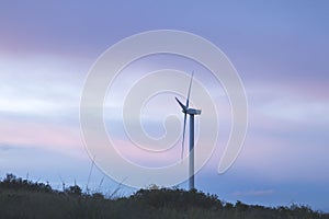 Wind turbine with beautiful sunset colorful stormy clouds