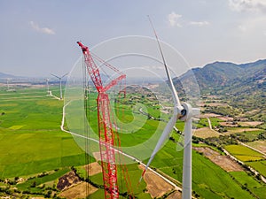 Wind turbine being repaired, assisted by crane and elevator. Wind power plant. green meadow with Wind turbines