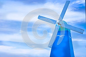 Wind turbine in the blue sky on a cloudy day