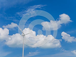 Wind turbine with blue sky and white clouds