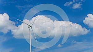 Wind turbine with blue sky and white clouds