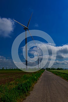 Wind turbine on a bright sunny day against the backdrop of a cloudy sky