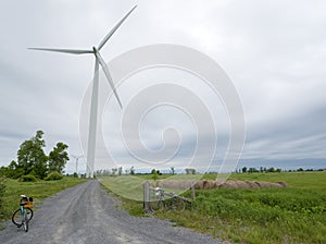 Wind turbine on a cloudy day with bikes in the foreground