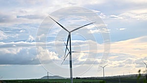 Wind turbine eco farm on beautiful golden hour evening mountain landscape.