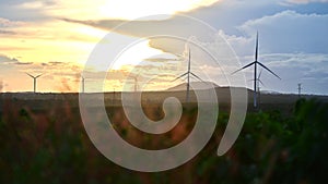 Wind turbine eco farm on beautiful golden hour evening mountain landscape.